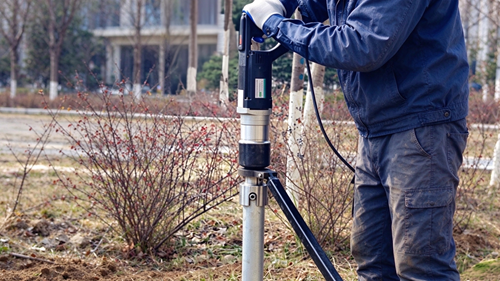 hand held ground screw drill working on site